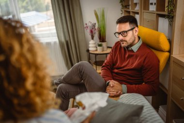 Psikoterapist kadın müşteriyi gözlemler ve sorunu hakkında düşünür.