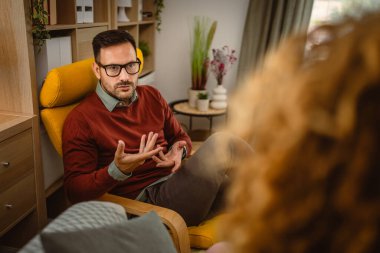 Psikoterapist kadın müşteriyi dinler ve ona destek ve tavsiye verir.