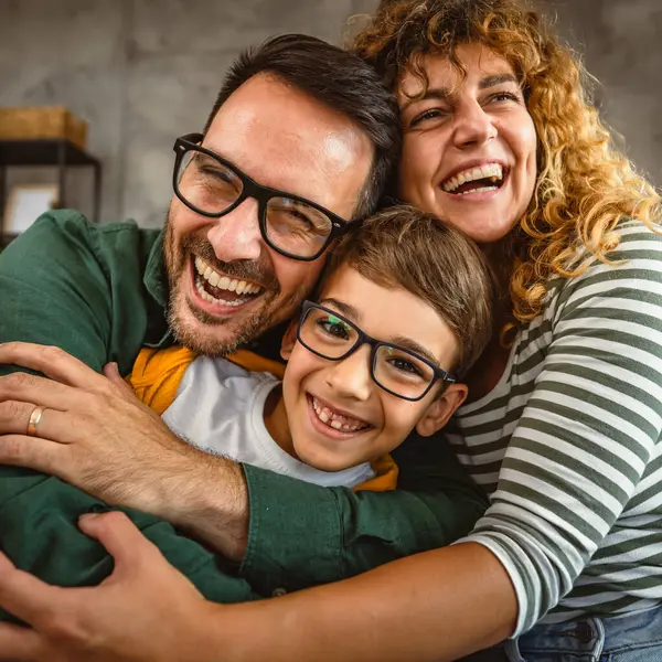 stock image Portrait of happy parents hug their son and enjoy together at home