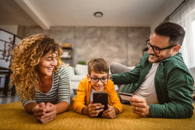 Anne, baba ve oğul internet üzerinden kredi kartıyla alışveriş yapıyorlar.