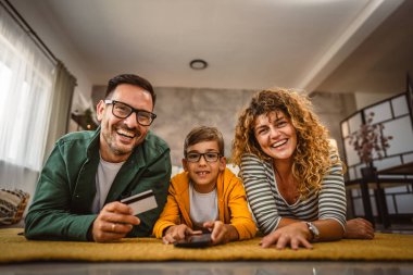 Anne, baba ve oğul internet üzerinden kredi kartıyla alışveriş yapıyorlar.