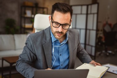 Kulaklıklı adam arka planda kız arkadaşı olan evden çalışıyor.