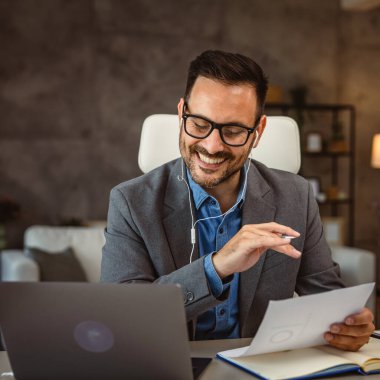 Kulaklıklı adam arka planda kız arkadaşı olan evden çalışıyor.