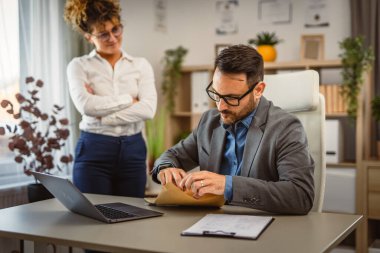 Erkek meslektaşım ofisteki kadın meslektaşımla birlikte zarfı açtı.