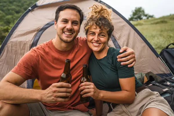 Stock image Portrait of happy smile couple with bottle of beer on camp