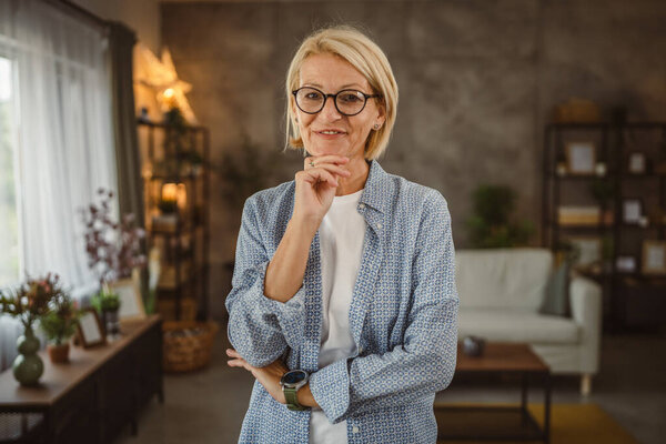 Portrait of beautiful mature senior woman stand and smile at home