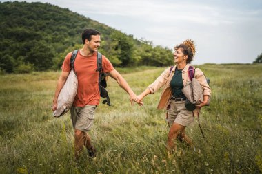 Erkek arkadaş ve kız arkadaş kamp malzemeleriyle ormanda dolaşıyorlar.