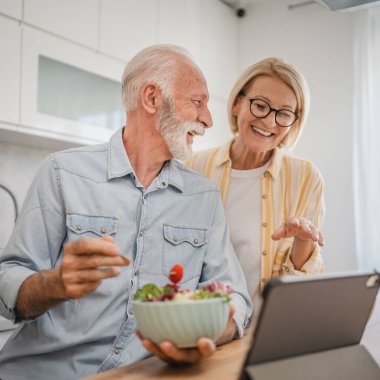 Üst düzey çiftler birlikte kahvaltı eder ve dijital tablet sabah rutini kullanırlar.