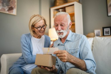 Yaşlı koca, olgun eşinden hediye olarak gelen tebrik kartını okudu.
