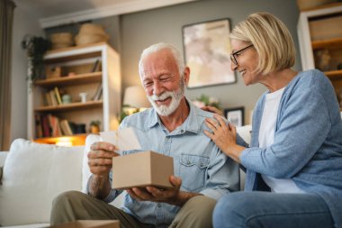Yaşlı koca, olgun eşinden hediye olarak gelen tebrik kartını okudu.