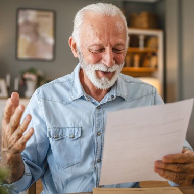 Kıdemli adam zarftan gelen iyi haberi okudu.