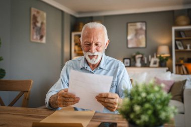 Kıdemli adam zarftan gelen iyi haberi okudu.