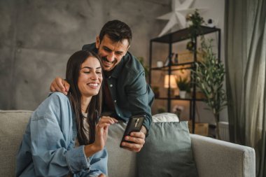 Erkek arkadaşı, kız arkadaşına evden çalışırken cep telefonu ekranını göstermiş.