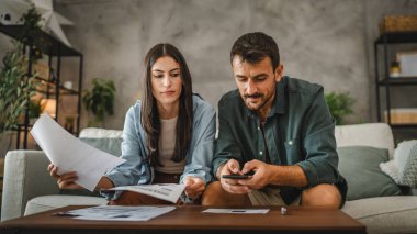 Adult man have contactless payment scan invoice on cellphone while his girlfriend sit next to her on sofa clipart