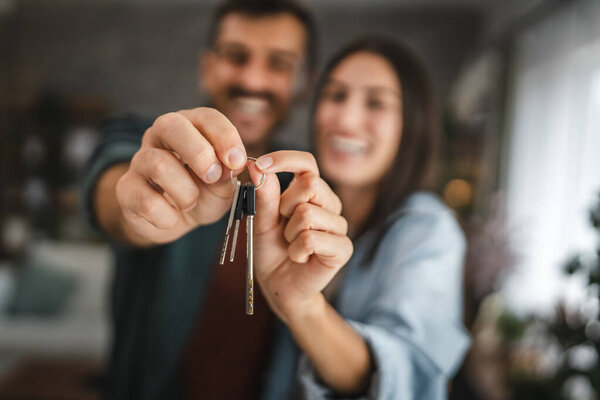 Close up of hands of couple hold key of their new home