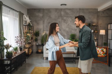 Yetişkin, neşeli çift evde sevgili dansı yapıyor.