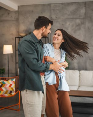 Yetişkin, neşeli çift evde sevgili dansı yapıyor.