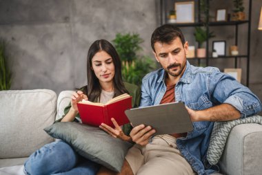 Sıradan bir çift kitap ve tabletle evde boş vakit geçirir.