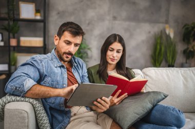 Sıradan bir çift kitap ve tabletle evde boş vakit geçirir.