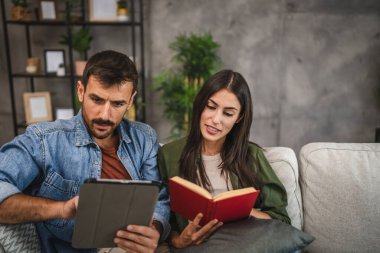 Sıradan bir çift kitap ve tabletle evde boş vakit geçirir.