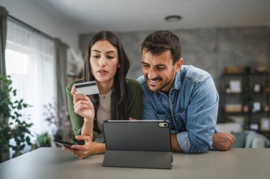 Kız arkadaşı cep telefonundan kredi kartı ve erkek arkadaşı satın alıyor. Yanında duruyor ve seçmesine yardım ediyor.