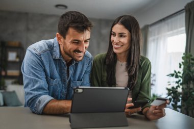 Kız arkadaşı cep telefonundan kredi kartı ve erkek arkadaşı satın alıyor. Yanında duruyor ve seçmesine yardım ediyor.