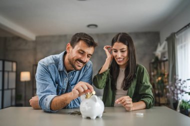 Yetişkin çift evdeki kumbarada para biriktiriyor.