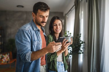Sevgilisi evde kahve içerken ona cep telefonu ekranını göster.