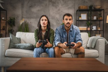 Odaklanmış yetişkin çift joystick 'te video oyunları oynamada yarışıyor
