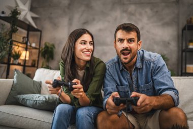 Yetişkin çiftler joystick 'te video oyunu oynarken eğleniyorlar.