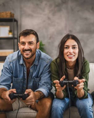 Yetişkin çiftler joystick 'te video oyunu oynarken eğleniyorlar.