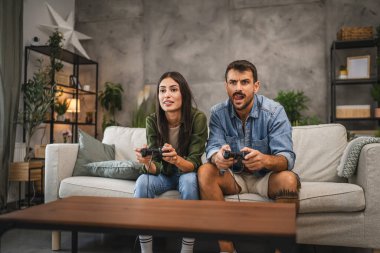 Odaklanmış yetişkin çift joystick 'te video oyunları oynamada yarışıyor