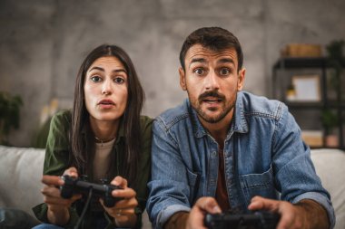 Odaklanmış yetişkin çift joystick 'te video oyunları oynamada yarışıyor