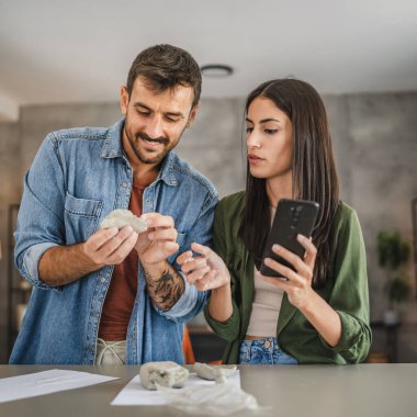 Çift cep telefonundan kil heykel ve çömlek yapmayı öğreniyor.