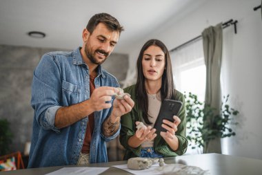 Çift cep telefonundan kil heykel ve çömlek yapmayı öğreniyor.