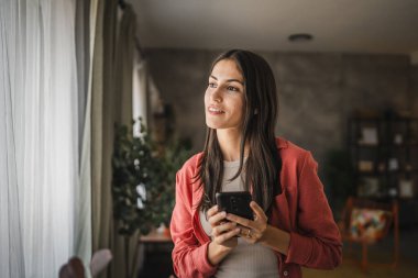 Yetişkin bir genç kadının portresi. Bekleyin ve cep telefonu kullanın.