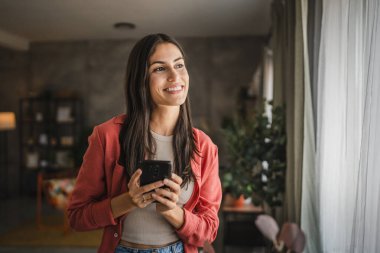 Yetişkin bir genç kadının portresi. Bekleyin ve cep telefonu kullanın.