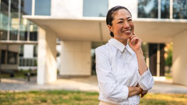 Modern binaların önünde olgun Japon iş kadını Stan 'in portresi.