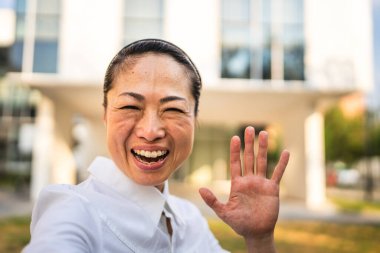 Modern binaların önündeki olgun Japon iş kadını Stan 'in portresi.