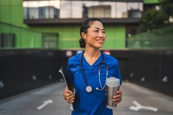 stock image portrait of japanese doctor stand and hold clipboard and thermos