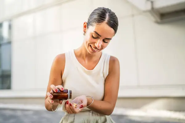 stock image Young woman take, drink medicament, medical therapy in front building