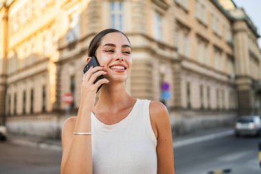 Sokakta cep telefonuyla konuşan güzel bir kadının portresi.