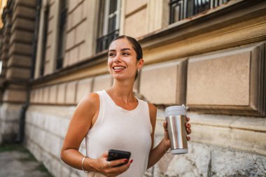 Genç ve güzel bir kadının portresi. Sokakta cep telefonu kullan.