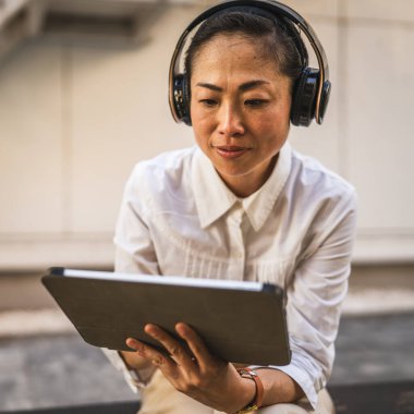 Olgun Japon kadın inşaat şirketinde dijital tablet kullanıyor.