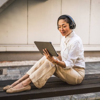 Olgun Japon kadın inşaat şirketinde dijital tablet kullanıyor.
