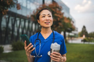 Japon doktor portresi. Ayağa kalk ve sokakta cep telefonu kullan.