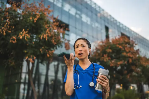 stock image Angry mature japanese woman doctor record voice mail on mobile phone