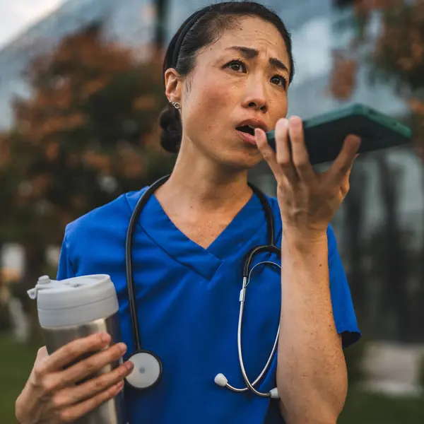 stock image Angry mature japanese woman doctor record voice mail on mobile phone