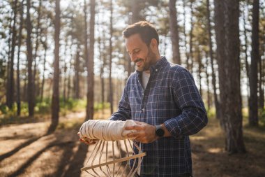 Yetişkin bir kampçı, hamağı salıncaktan sonra sırt çantasına koyar.