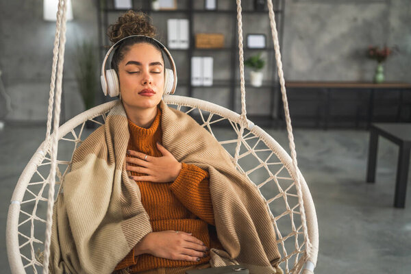 Одна женщина взрослая кавказская женщина тысячелетия с помощью наушников для онлайн-медитации практикуя внимательность йоги с закрытыми глазами дома реальные люди концепции самопомощи скопировать пространство